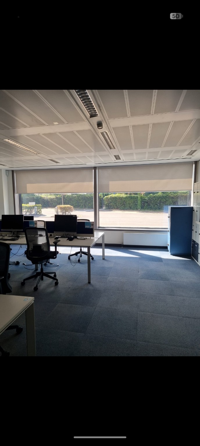 Two roller blinds shading a workspace